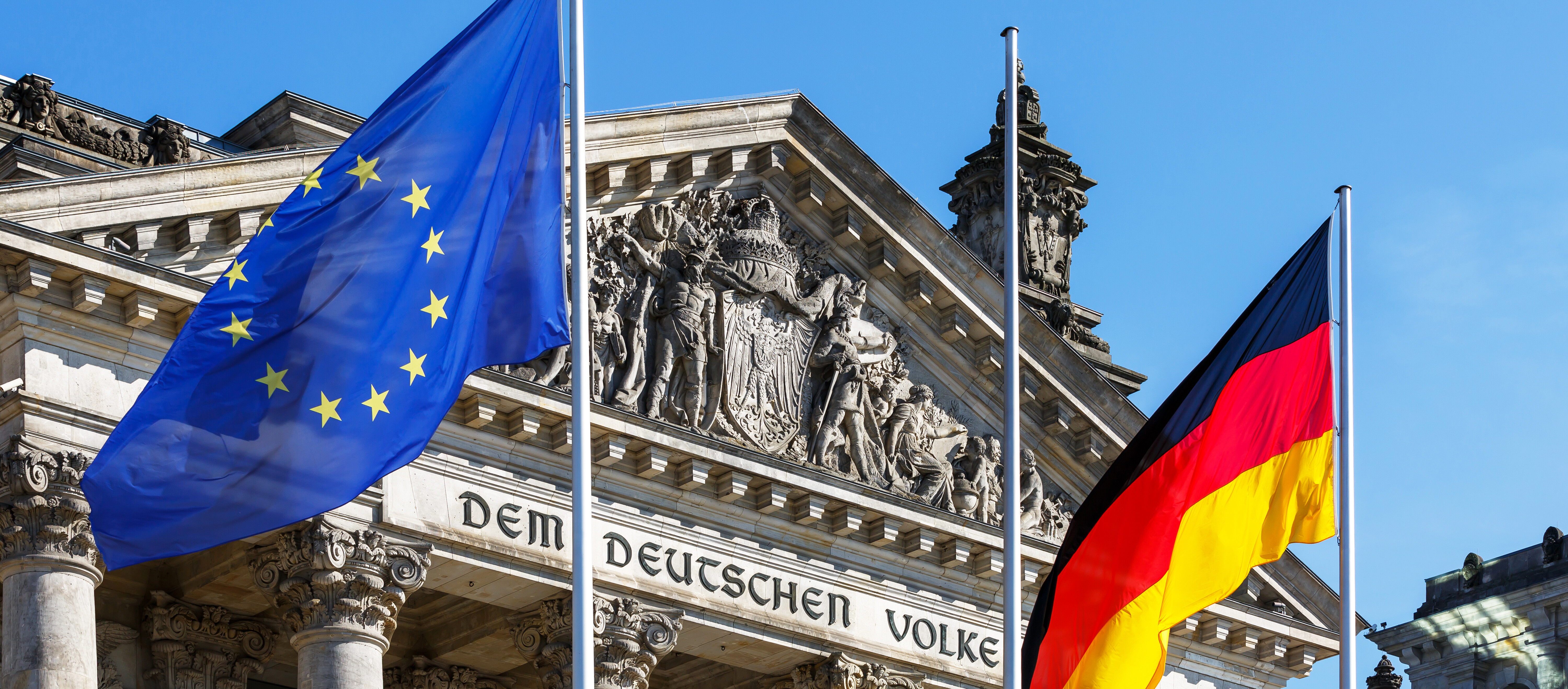 EU- und deutsche Flagge wehen vor dem Reichstagsgebäude in Berlin.