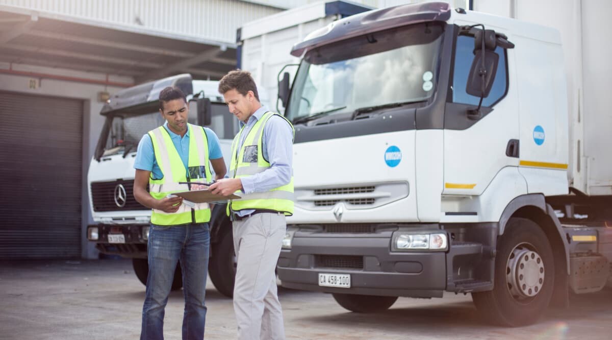 Lkw-Fahrer vor ihren Fahrzeugen