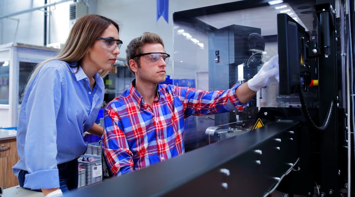 Geschäftskollegen mit Computer in industrieller Produktionslinie